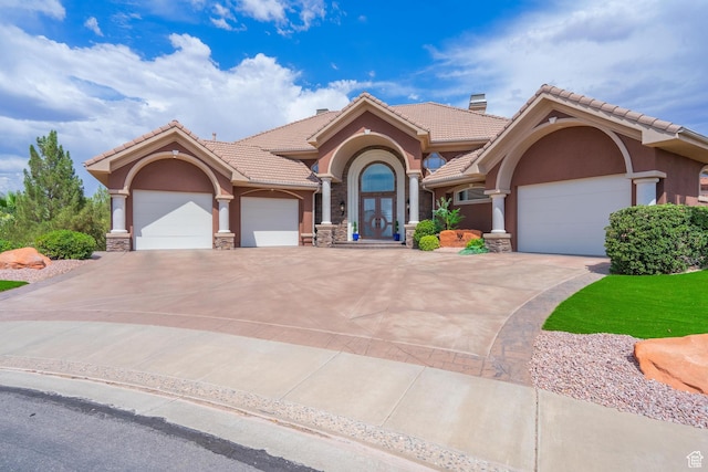 16 N Lions Head Cir, Washington, UT 84780 - mediterranean / spanish house featuring stucco siding, an attached garage, concrete driveway, a tile roof, and stone siding