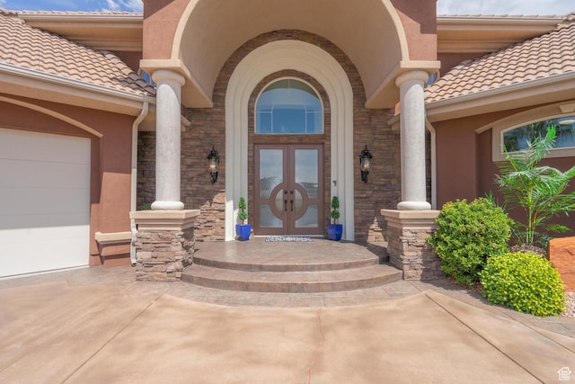 16 N Lions Head Cir, Washington, UT 84780 - doorway to property with a tiled roof, stucco siding, stone siding, french doors, and an attached garage