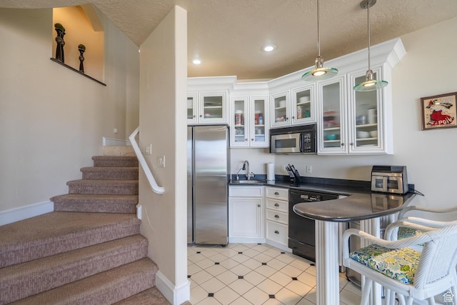 16 N Lions Head Cir, Washington, UT 84780 - kitchen featuring appliances with stainless steel finishes, dark countertops, white cabinets, pendant lighting, and glass insert cabinets