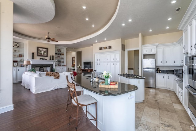 16 N Lions Head Cir, Washington, UT 84780 - kitchen featuring freestanding refrigerator, a kitchen island with sink, open floor plan, a fireplace, and ceiling fan