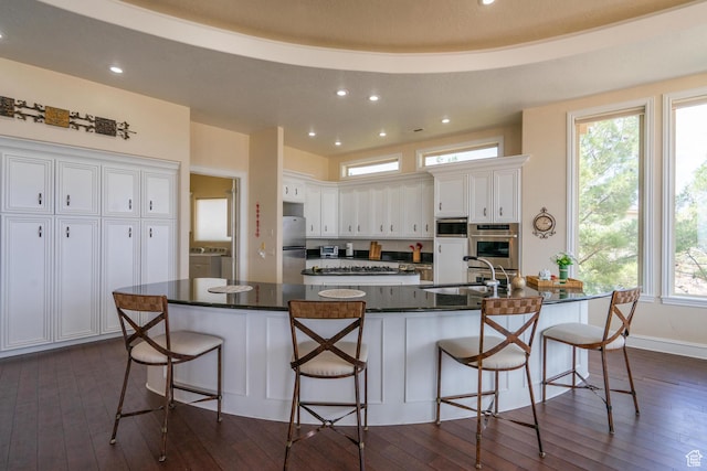 16 N Lions Head Cir, Washington, UT 84780 - kitchen with appliances with stainless steel finishes, white cabinets, dark wood-style floors, recessed lighting, and a breakfast bar