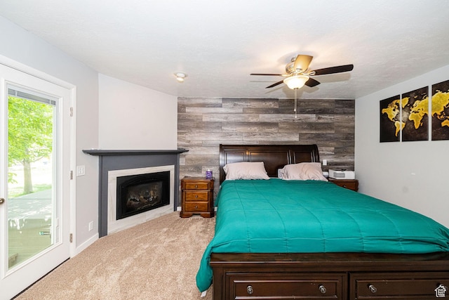 5883 S Jared Way E, South Ogden, UT 84403 - carpeted bedroom with an accent wall, a fireplace, access to outside, a ceiling fan, and wooden walls