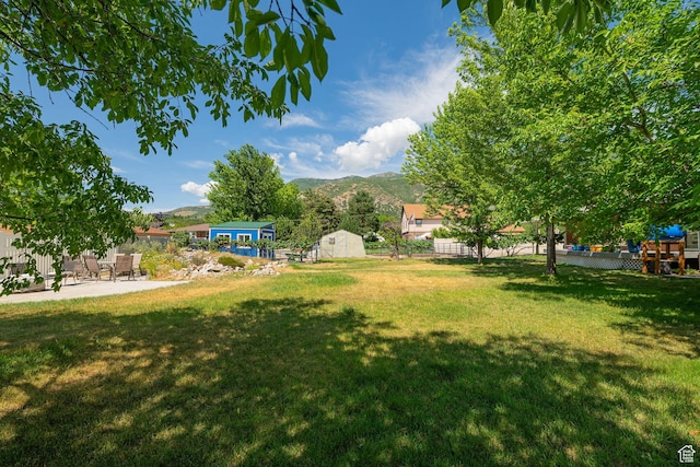 5883 S Jared Way E, South Ogden, UT 84403 - view of yard featuring a mountain view, a storage unit, and a patio area