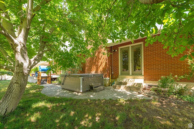 5883 S Jared Way E, South Ogden, UT 84403 - view of green lawn featuring a hot tub, a patio, and entry steps