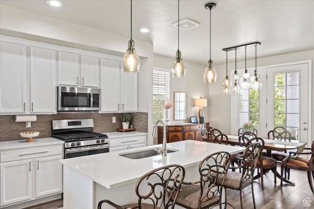 5328 W S Jordan Pkwy S, South Jordan, UT 84009 - kitchen featuring appliances with stainless steel finishes, healthy amount of natural light, a kitchen bar, backsplash, and recessed lighting
