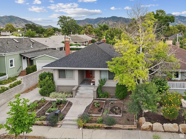 1873 S Lincoln St E, Salt Lake City, UT 84105 - view of front of property with a vegetable garden, roof with shingles, a mountain view, a chimney, and a residential view