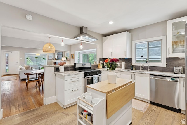 1873 S Lincoln St E, Salt Lake City, UT 84105 - kitchen featuring stainless steel appliances, range hood, a peninsula, healthy amount of natural light, and recessed lighting