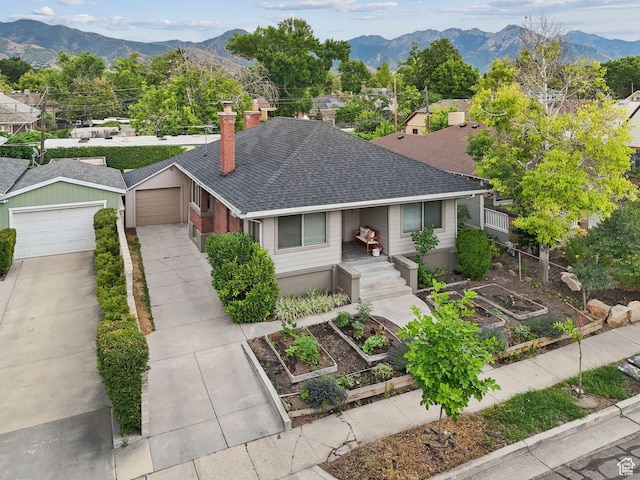 1873 S Lincoln St E, Salt Lake City, UT 84105 - view of front facade featuring a garden, a chimney, roof with shingles, a mountain view, and a garage