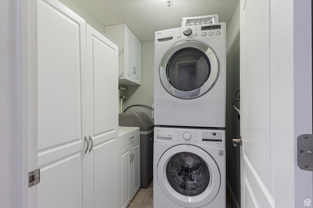 3075 E Kennedy Dr Unit 315, Salt Lake City, UT 84108 - laundry area with stacked washer / dryer, cabinet space, and a textured ceiling