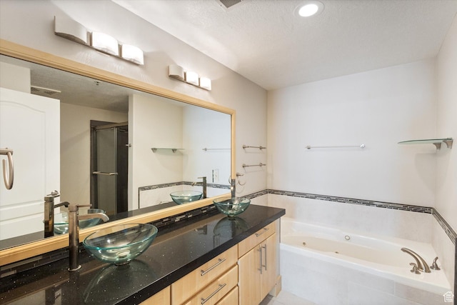 3075 E Kennedy Dr Unit 315, Salt Lake City, UT 84108 - full bathroom featuring a tub with jets, double vanity, a stall shower, and a textured ceiling