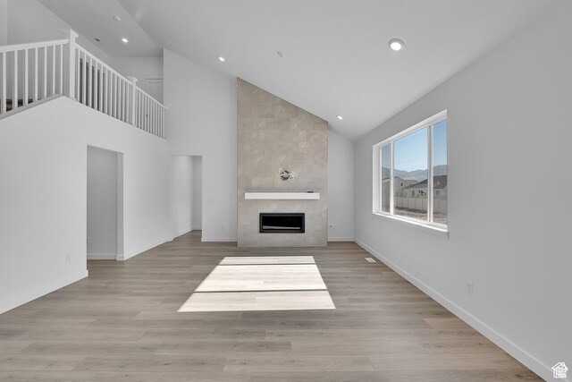 1089 S 3170 E Unit 205, Spanish Fork, UT 84660 - unfurnished living room featuring a large fireplace, recessed lighting, high vaulted ceiling, and wood finished floors