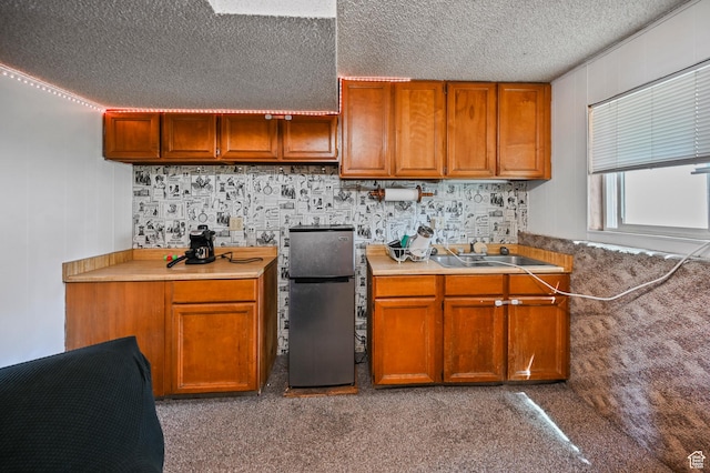 308 W 1050 N, Logan, UT 84321 - kitchen featuring freestanding refrigerator, a textured ceiling, brown cabinetry, and light countertops