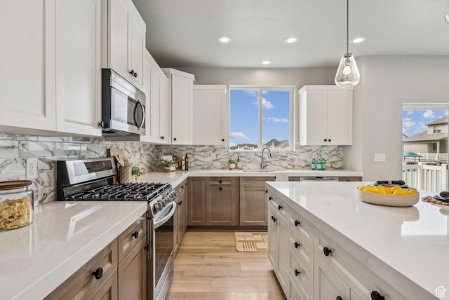 4269 W 2025 S, West Haven, UT 84401 - kitchen with appliances with stainless steel finishes, recessed lighting, tasteful backsplash, white cabinets, and hanging light fixtures