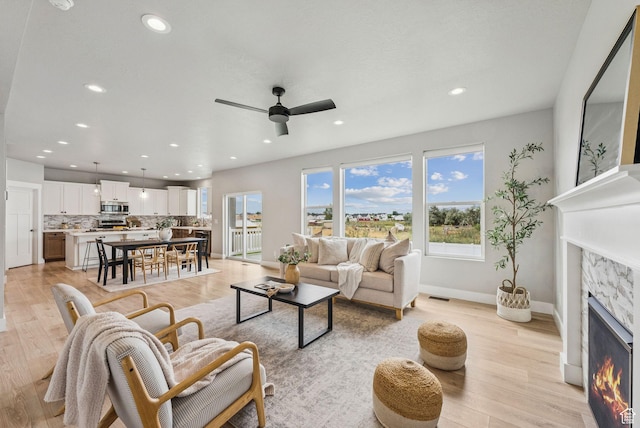 4269 W 2025 S, West Haven, UT 84401 - living area with a lit fireplace, ceiling fan, light wood-style flooring, and recessed lighting