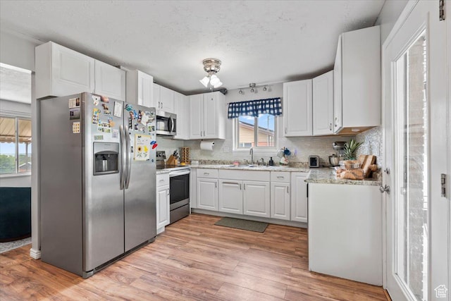 446 Robins Ave, Ogden, UT 84404 - kitchen with appliances with stainless steel finishes, a textured ceiling, tasteful backsplash, and light wood finished floors