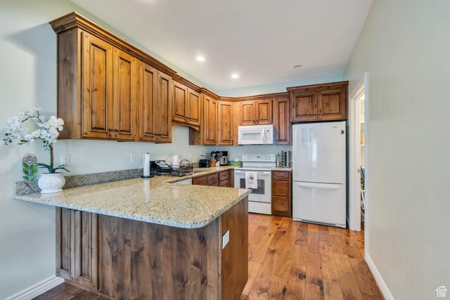 588 S 350 E, Pleasant Grove, UT 84062 - kitchen featuring white appliances, a peninsula, light wood-style floors, brown cabinets, and recessed lighting