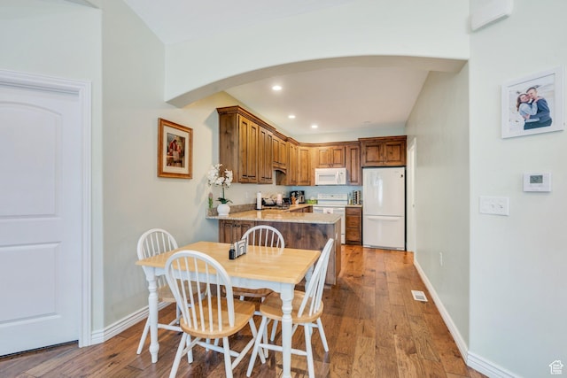 588 S 350 E, Pleasant Grove, UT 84062 - kitchen featuring white appliances, arched walkways, a peninsula, recessed lighting, and brown cabinets
