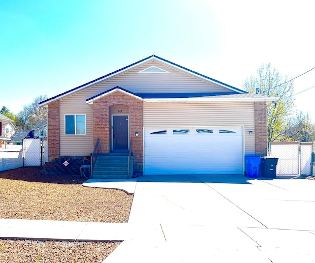 560 E 700 N, Logan, UT 84321 - view of front of house with a gate, brick siding, an attached garage, and driveway