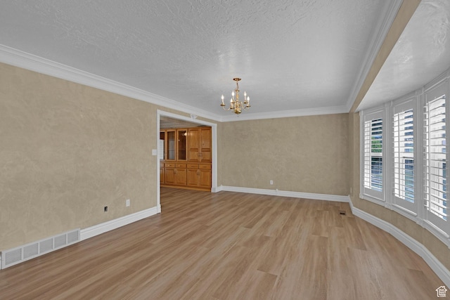 192 N Highland Blvd, Brigham City, UT 84302 - spare room featuring light wood-style floors, a chandelier, ornamental molding, and a textured ceiling