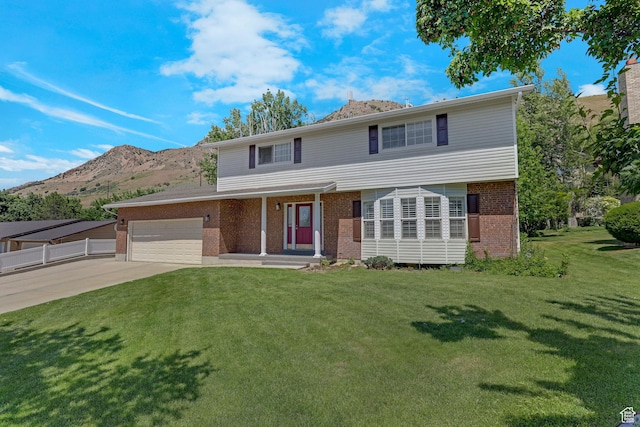 192 N Highland Blvd, Brigham City, UT 84302 - view of front of house with brick siding, a garage, concrete driveway, and a mountain view