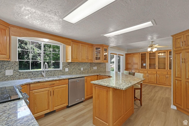192 N Highland Blvd, Brigham City, UT 84302 - kitchen with dishwasher, a textured ceiling, light wood-style flooring, a breakfast bar, and plenty of natural light