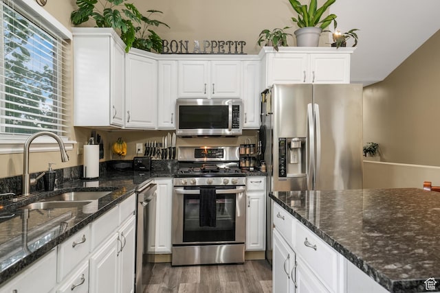 3561 S Jenelles Bay, West Valley City, UT 84119 - kitchen featuring stainless steel appliances, white cabinetry, wood finished floors, and dark stone counters