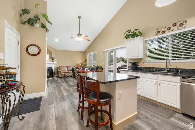 3561 S Jenelles Bay, West Valley City, UT 84119 - kitchen with dishwasher, high vaulted ceiling, dark stone counters, a kitchen island, and light wood-style flooring