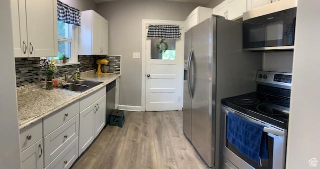 2425 Van Buren Ave, Ogden, UT 84401 - kitchen featuring stainless steel appliances, light wood-style floors, backsplash, white cabinets, and light stone countertops