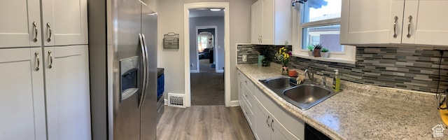 2425 Van Buren Ave, Ogden, UT 84401 - kitchen featuring stainless steel fridge, light wood-style flooring, white cabinetry, and decorative backsplash