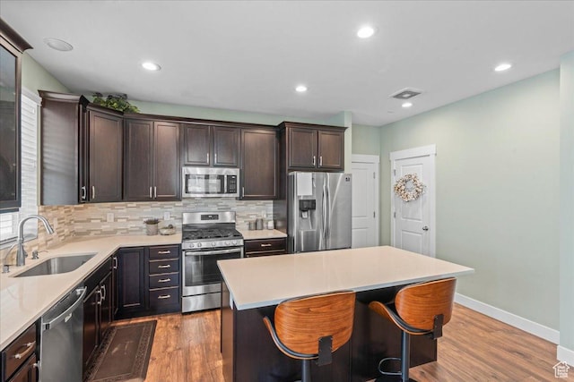 5131 W Mellow Way S, South Jordan, UT 84009 - kitchen with stainless steel appliances, decorative backsplash, dark brown cabinetry, light wood-style floors, and recessed lighting