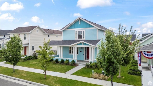 5131 W Mellow Way S, South Jordan, UT 84009 - view of front of house featuring board and batten siding, covered porch, and a front lawn