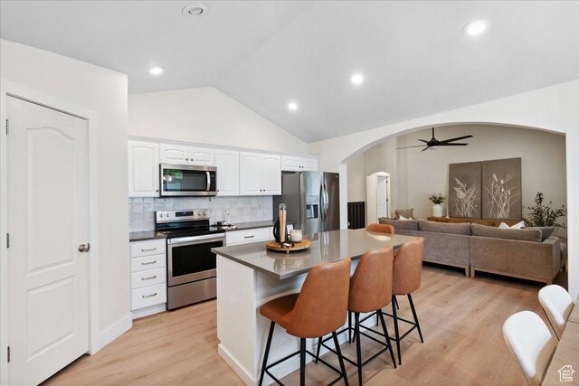 656 W 1310 N, Lehi, UT 84043 - kitchen with appliances with stainless steel finishes, arched walkways, a kitchen bar, white cabinets, and a kitchen island
