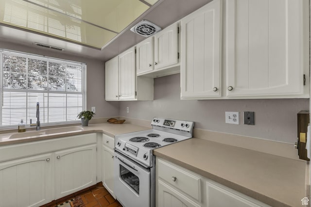 607 E 4030 S, Murray, UT 84107 - kitchen featuring white electric stove, white cabinets, light countertops, and brick patterned floors