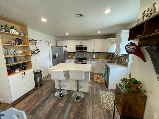 4825 S 4480 W, Kearns, UT 84118 - kitchen featuring stainless steel appliances, white cabinetry, dark wood-style flooring, tasteful backsplash, and light countertops