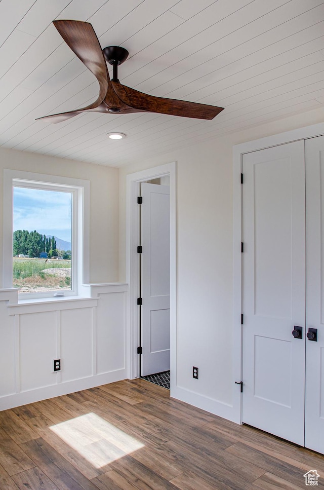 5958 W Sunridge View Ln, Payson, UT 84651 - unfurnished bedroom featuring wood ceiling, wood finished floors, a wainscoted wall, a closet, and a ceiling fan