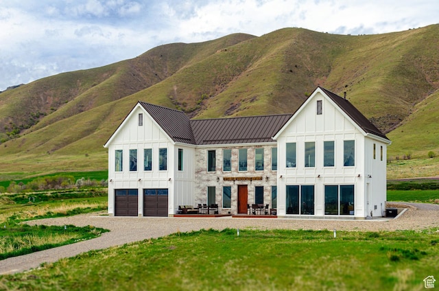 5958 W Sunridge View Ln, Payson, UT 84651 - back of house with board and batten siding, a garage, gravel driveway, a mountain view, and a standing seam roof