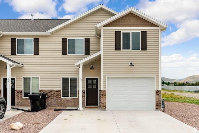87 E Legacy Dr, Franklin, ID 83237 - view of front of home featuring brick siding, a mountain view, an attached garage, and driveway