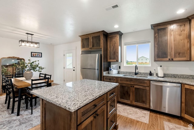 87 E Legacy Dr, Franklin, ID 83237 - kitchen with stainless steel appliances, light wood-style floors, plenty of natural light, light stone countertops, and recessed lighting