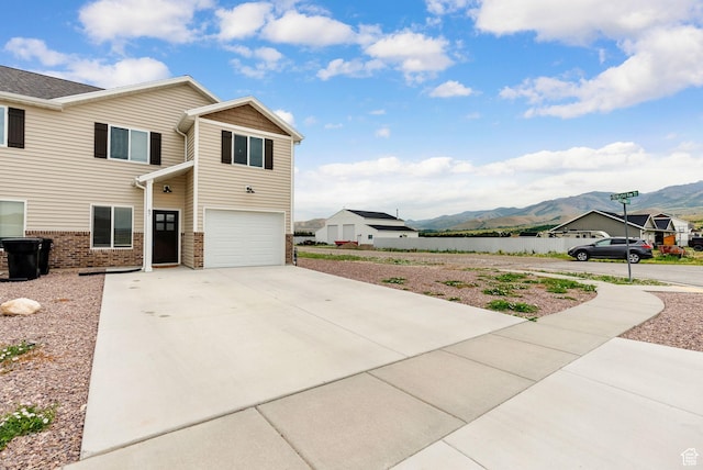 87 E Legacy Dr, Franklin, ID 83237 - view of side of property featuring a mountain view, an attached garage, concrete driveway, and brick siding