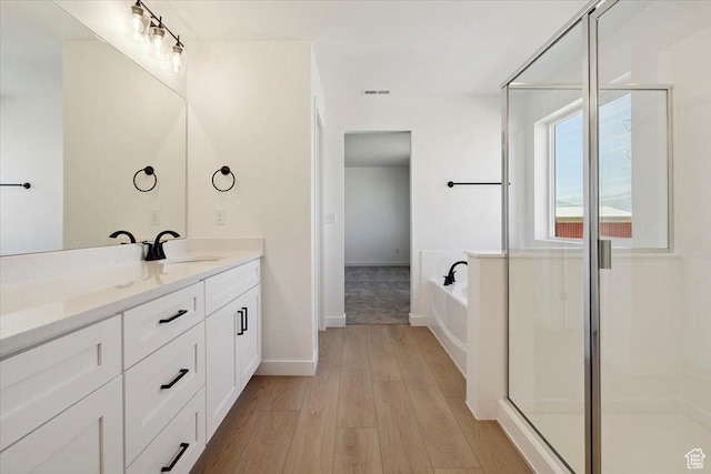 723 N Plainsman Dr Unit 109, Spanish Fork, UT 84660 - full bathroom featuring double vanity, wood finished floors, a bath, and a stall shower