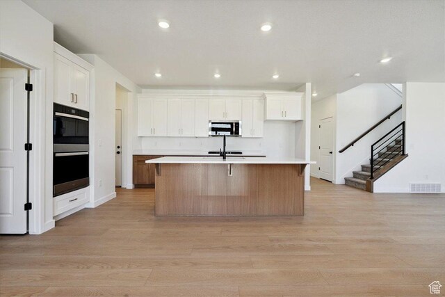 723 N Plainsman Dr Unit 109, Spanish Fork, UT 84660 - kitchen featuring stainless steel microwave, light wood finished floors, recessed lighting, light countertops, and white cabinetry
