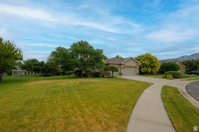 10453 N Canterbury Pl, Highland, UT 84003 - obstructed view of property featuring concrete driveway, a front lawn, an attached garage, stucco siding, and a mountain view