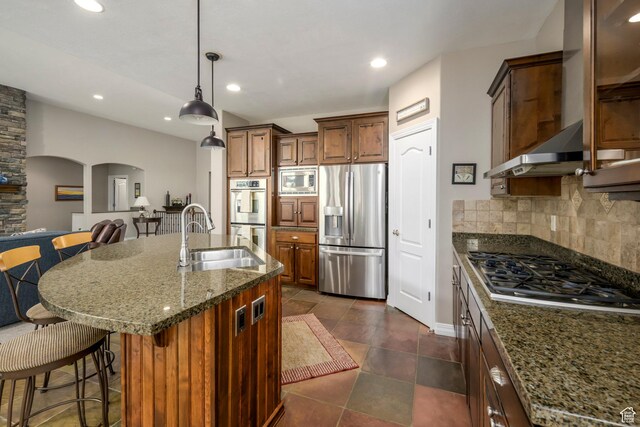10453 N Canterbury Pl, Highland, UT 84003 - kitchen featuring appliances with stainless steel finishes, a breakfast bar, backsplash, arched walkways, and recessed lighting