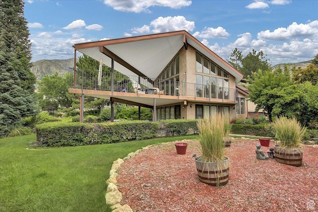 490 E 3475 N, North Ogden, UT 84414 - back of property with stucco siding, a lawn, a mountain view, and a balcony