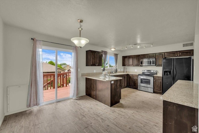 328 Pectol St, Washington, UT 84780 - kitchen with appliances with stainless steel finishes, dark brown cabinets, light wood finished floors, a peninsula, and decorative light fixtures