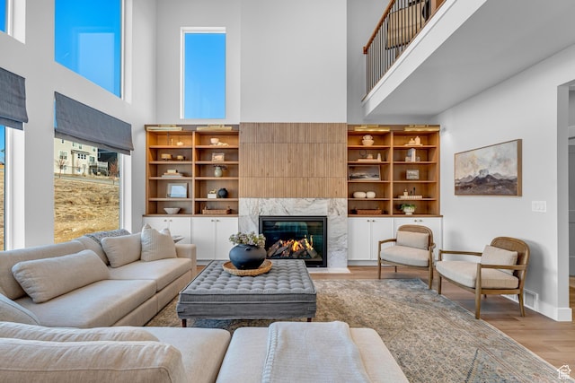6957 W Farnsworth Peak Dr S Unit 314, West Jordan, UT 84081 - living room featuring a high ceiling, light wood-type flooring, and a high end fireplace