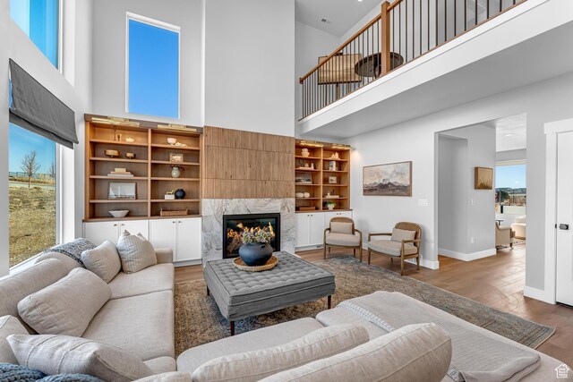 6957 W Farnsworth Peak Dr S Unit 314, West Jordan, UT 84081 - living room featuring a high ceiling, a fireplace, wood finished floors, and healthy amount of natural light