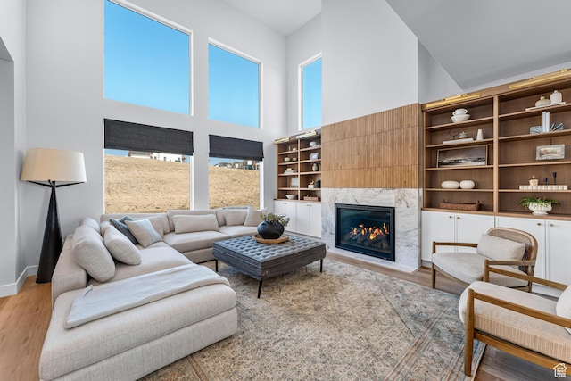 6957 W Farnsworth Peak Dr S Unit 314, West Jordan, UT 84081 - living area featuring a towering ceiling, light wood finished floors, and a premium fireplace