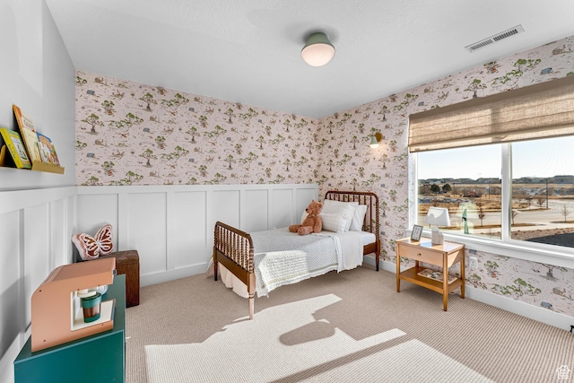 6957 W Farnsworth Peak Dr S Unit 314, West Jordan, UT 84081 - bedroom with wallpapered walls, a wainscoted wall, carpet floors, and a decorative wall