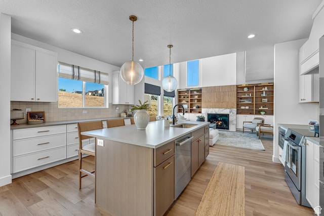 6957 W Farnsworth Peak Dr S Unit 314, West Jordan, UT 84081 - kitchen featuring stainless steel appliances, a kitchen island with sink, light wood-style floors, white cabinets, and recessed lighting